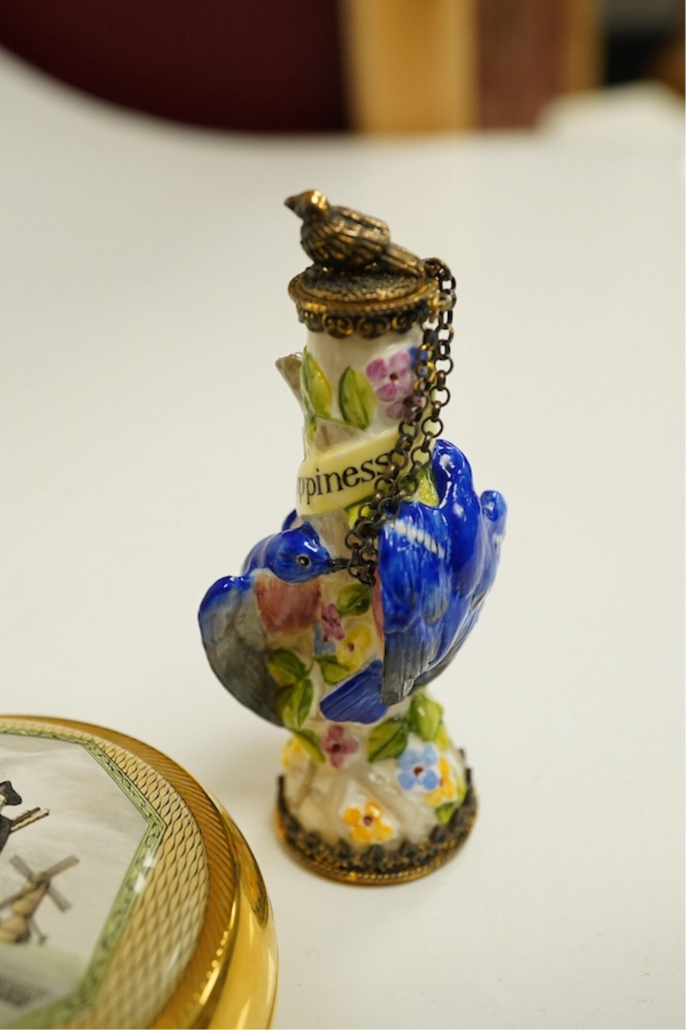 A miniature porcelain egg shaped scent bottle, on chain, two Halcyon Days scent bottles and a circular enamelled paperweight, (4). Condition - fair